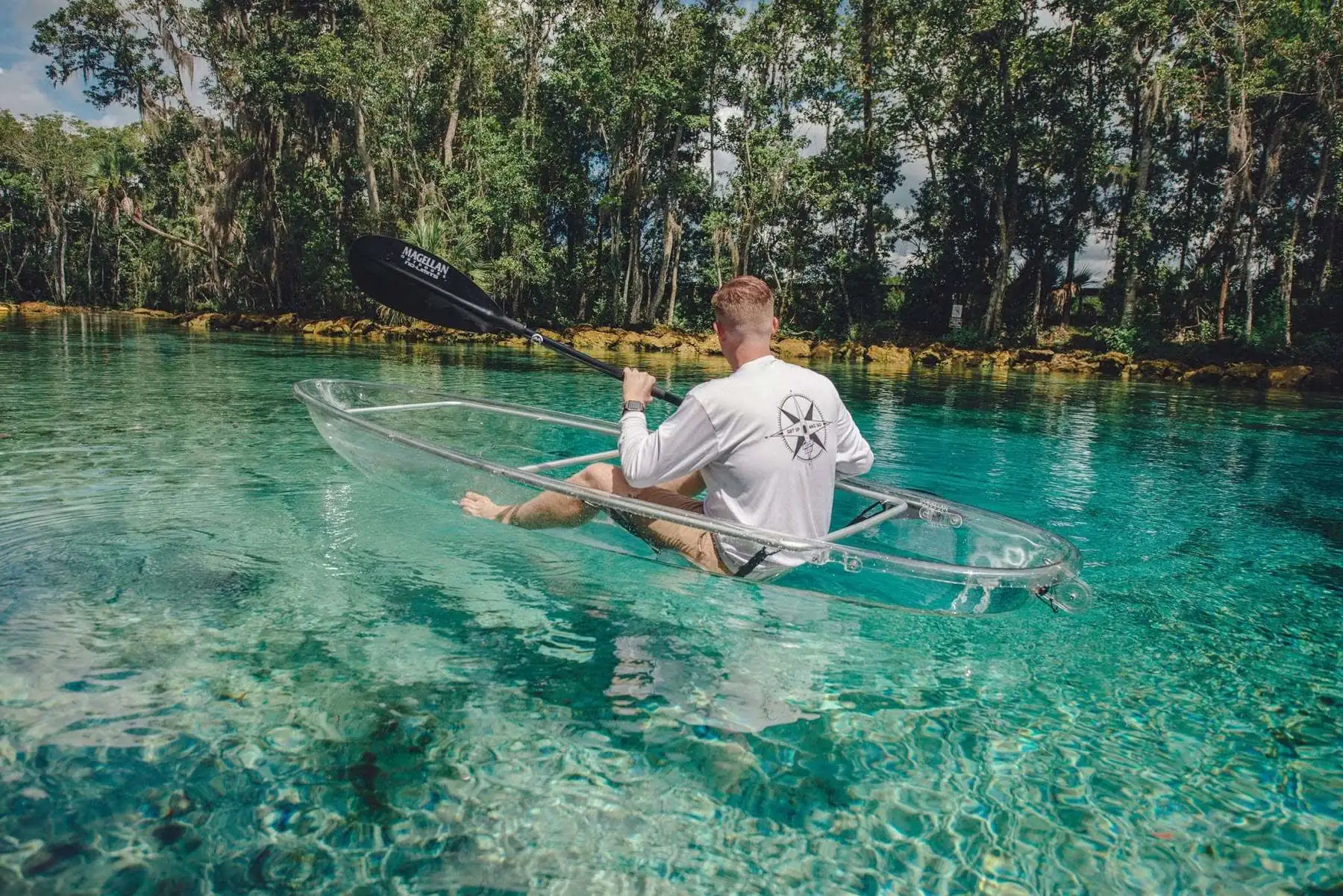 A paddler in a clear kayak at Three Sisters Springs