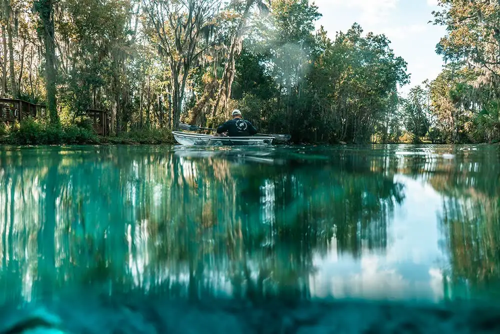 Split-level view of a clear kayak above a spring floor